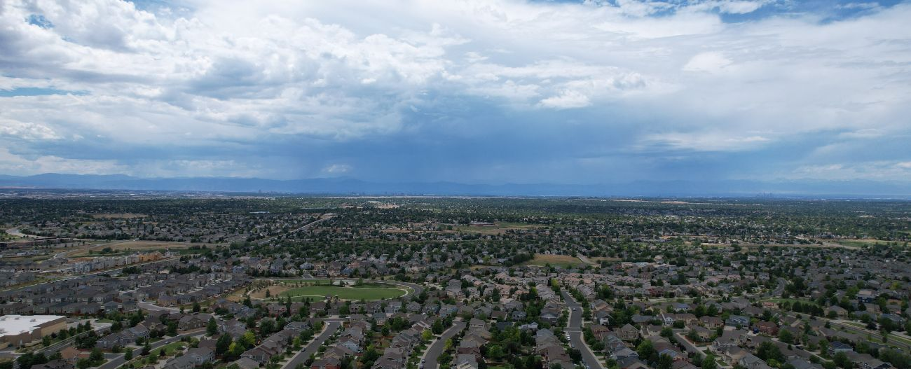 Aerial view of a residential neighborhood with mountain range in the background