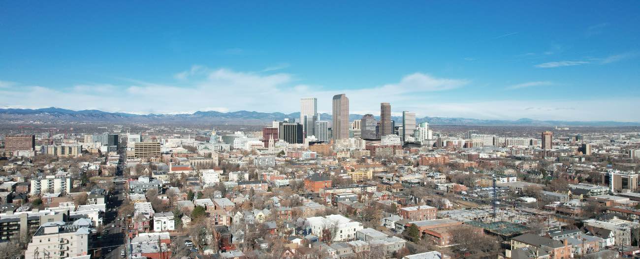 Aerial view of a downtown city with a mountain range in the background