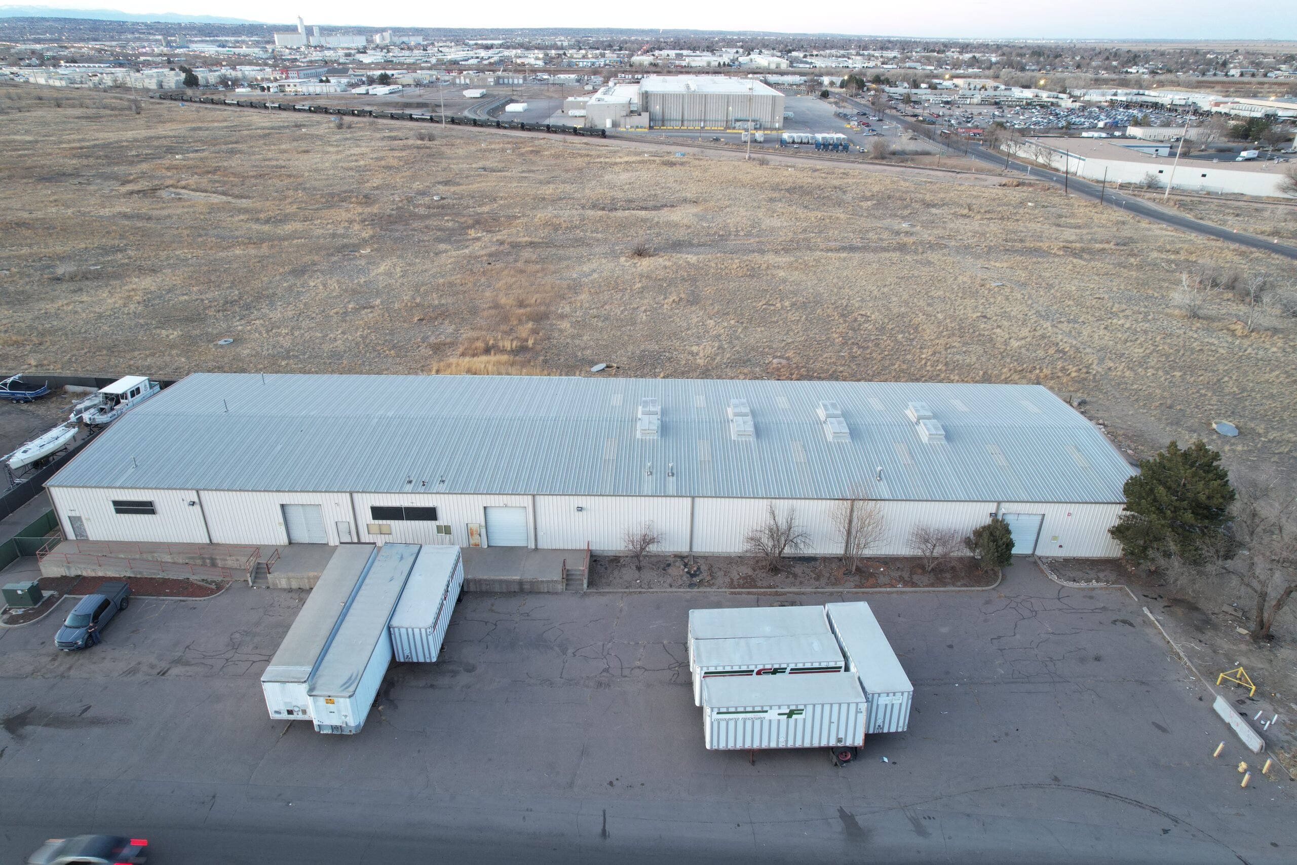 Aerial overhead view of industrial building with white metal walls and grey metal roof